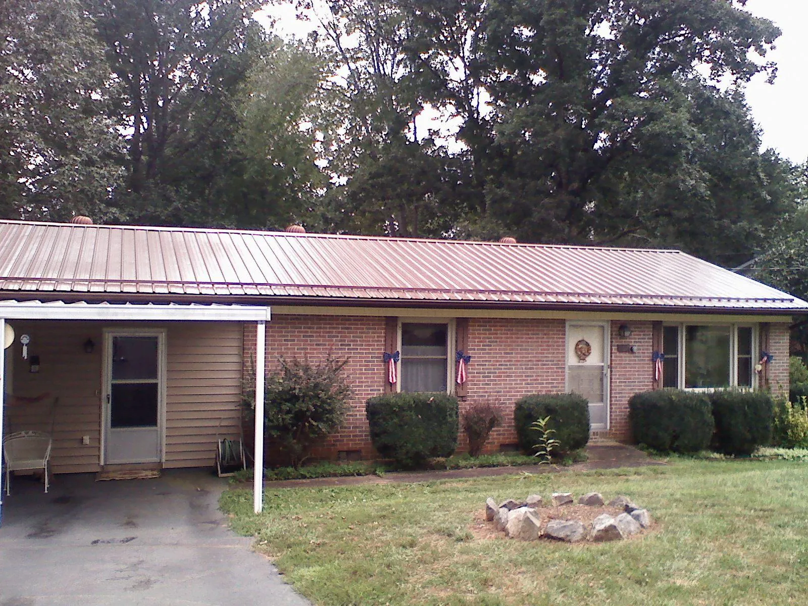 Bronze metal roof and carport on a brick ranch home — Roof Repair work by our crew in Kent